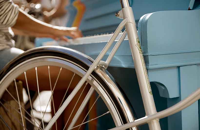 Haar slanke buizen die samenkomen in retro lugs, de glimmende stalen spatborden en de retro racebanden: